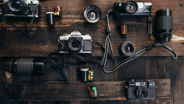 Tafel vol verschillende compactcamera’s en accessoires.